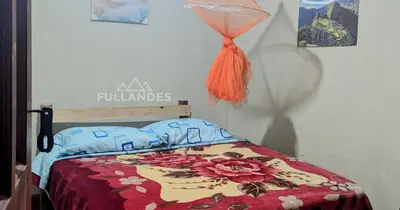 a bedroom with a bed with a floral comforter at Casitas Choquequirao Chikiska in Abancay