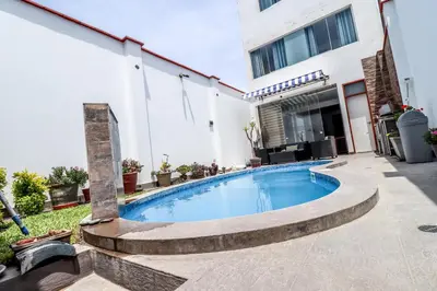 a swimming pool in the backyard of a house at CERRO AZUL Alojamiento DUPLEX in Cerro Azul