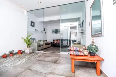 a living room with a glass wall at CERRO AZUL Alojamiento DUPLEX in Cerro Azul