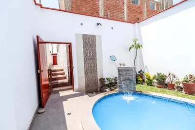 a swimming pool in a courtyard with a house at CERRO AZUL Alojamiento DUPLEX in Cerro Azul