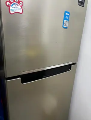 a stainless steel refrigerator with stickers on it at Habitación privada en departamento compartido in Lima