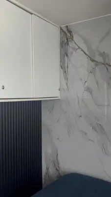 a white marble wall with a cabinet in a room at Habitación privada en departamento compartido in Lima