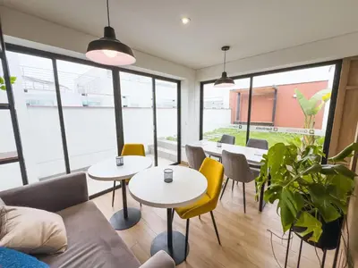 a room with two tables and chairs and windows at Habitación privada en departamento compartido in Lima