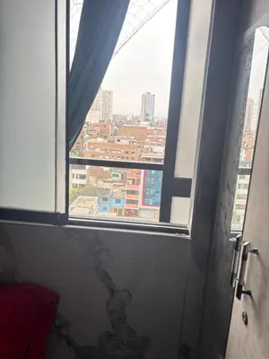 a window in a room with a view of a city at Cuarto privado en departamento compartido in Lima