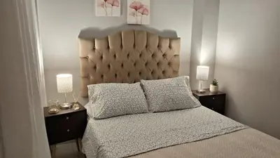 a bedroom with a large bed with two lamps on tables at Relax Department in Lima
