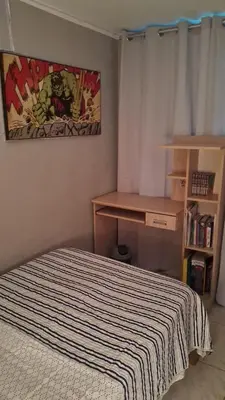 a small bedroom with a bed and a desk at Relax Department in Lima