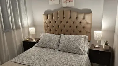 a bedroom with a large bed with two lamps on night stands at Relax Department in Lima