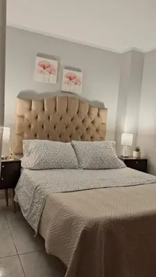 a bedroom with a large bed with two pictures on the wall at Relax Department in Lima