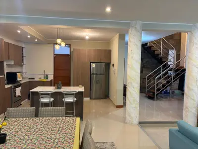 a kitchen and a living room with a spiral staircase at Villa Luna in Cieneguilla
