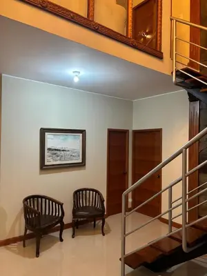 a room with two chairs and a staircase at Villa Luna in Cieneguilla