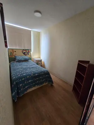 a bedroom with a bed with a blue comforter at Los Nogales LS in Lima