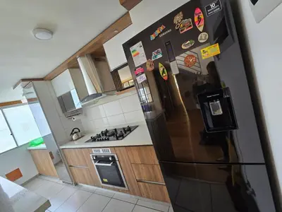 a kitchen with a black refrigerator with magnets on it at Los Nogales LS in Lima