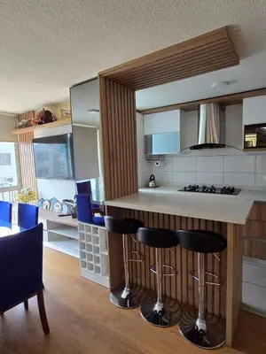 a kitchen with a counter and some blue bar stools at Los Nogales LS in Lima