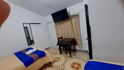 a bedroom with a bed and a television and a desk at Altos Del Valle in Cusco
