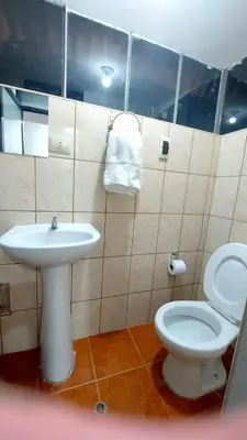 a bathroom with a white toilet and a sink at Altos Del Valle in Cusco