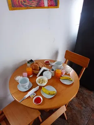 a wooden table with breakfast foods and orange juice at Altos Del Valle in Cusco