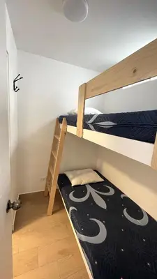 a bedroom with two bunk beds with a black and white blanket at Casa Playa Azul Verano 2026 Asia in Cerro Azul