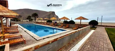 a swimming pool with chairs and umbrellas next to the beach at Casa Playa Azul Verano 2026 Asia in Cerro Azul
