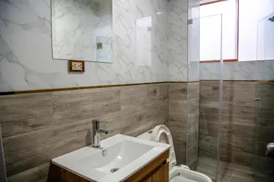 a bathroom with a sink and a toilet and a mirror at HOTEL TERRANOVA Abancay in Abancay