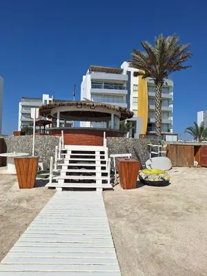 a staircase leading to a building with a palm tree at Paracas Exclusivo Departamento familiar in Pisco