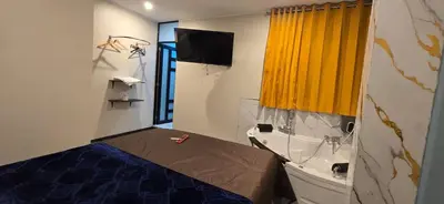 a bedroom with a bed and a yellow curtain at Hotel gym club33 in Huancayo