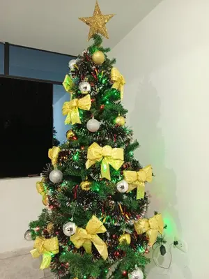 a christmas tree with yellow bows and a star at Casa rústica in Ica