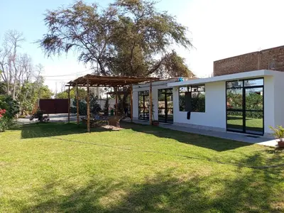 a house with a large yard with a grass field at Casa rústica in Ica