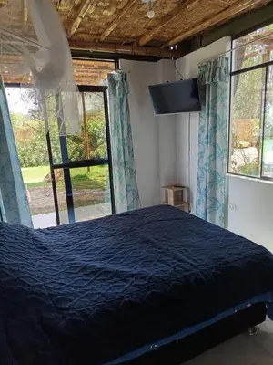 a bedroom with a bed and two windows at Casa rústica in Ica