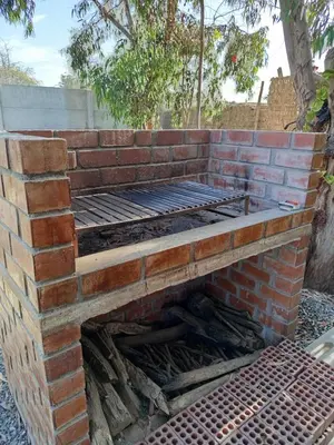 an outdoor brick fireplace with the top off at Casa rústica in Ica