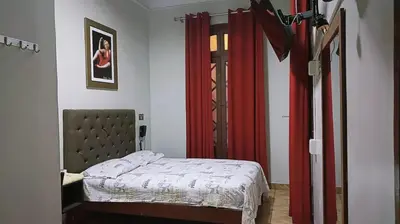 a bedroom with a bed and a red curtain at Anciejo inn ll in Lima