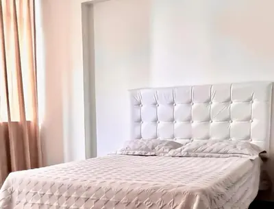 a white bed with a large white headboard in a bedroom at Smart apart in Lima