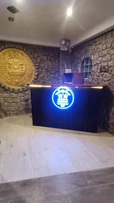 a bar with a sign on a stone wall at Hotel Wasichay - Santa teresa in Santa Teresa