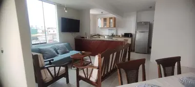 a kitchen with a couch and a table and chairs at Departamento en Playa Pulpos - 2 habitaciones - Piscina compartida in Arica