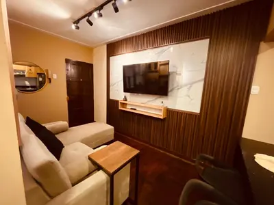 a living room with a couch and a flat screen tv at Estancia Ideal in Lima