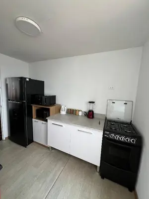 a kitchen with a stove and a black refrigerator at Prescott Apartment San Isidrio in Lima