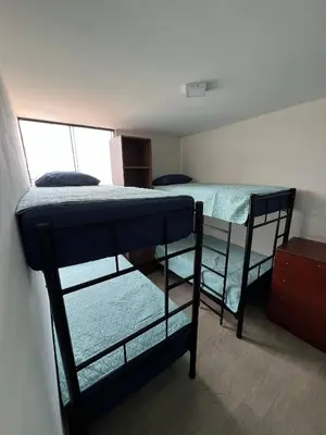 two bunk beds in a room with a window at Prescott Apartment San Isidrio in Lima