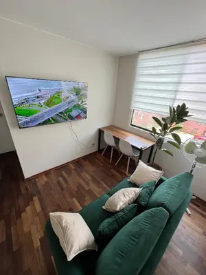 a living room with a green couch and a table at Prescott Apartment San Isidrio in Lima