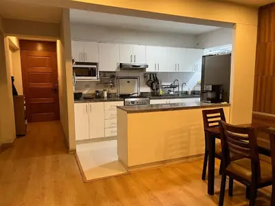 a kitchen with white cabinets and a table and chairs at Room with 2 beds - Shared Apartment in Lima