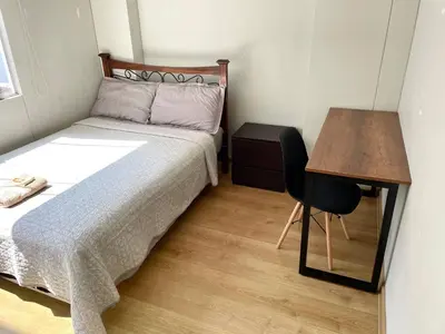 a small bedroom with a bed and a desk at Room with 2 beds - Shared Apartment in Lima