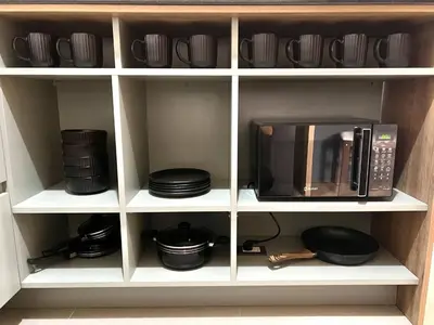 a kitchen shelf with a microwave and plates and pans at Modern Apartment for 9 San Isidro in Lima