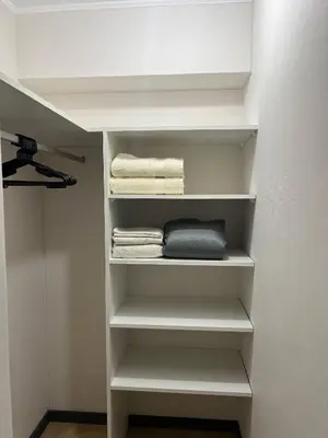 a walk in closet with white shelves and towels at Modern Apartment for 9 San Isidro in Lima