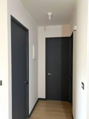 two black doors in a room with wooden floors at Modern Apartment for 9 San Isidro in Lima