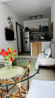 a glass table with a vase of flowers on top of a kitchen at Mini in Punta Hermosa