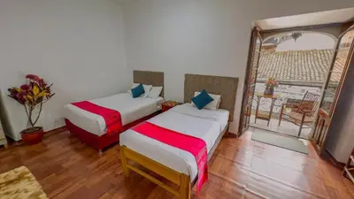 a bedroom with two beds and a window with a balcony at Casona MICA'S HOUSE in Cusco