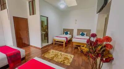 a room with two beds and a vase of flowers at Casona MICA'S HOUSE in Cusco