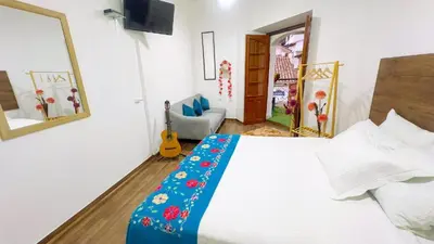 a bedroom with a bed with a blue blanket on it at Casona MICA'S HOUSE in Cusco