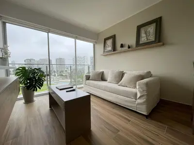 a living room with a white couch and a table at BOEM Apartments by Vibrant in Lima