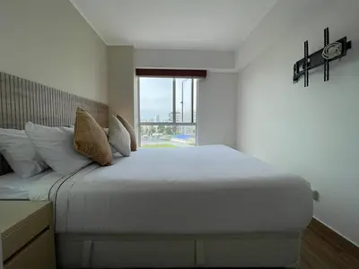 a bedroom with a large white bed with a window at BOEM Apartments by Vibrant in Lima