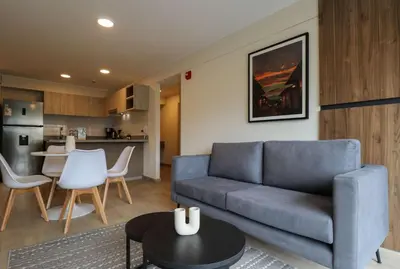a living room with a blue couch and a kitchen at Larco by Wynwood House in Lima