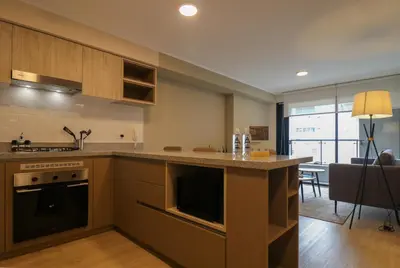 a kitchen with a counter and a living room at Larco by Wynwood House in Lima